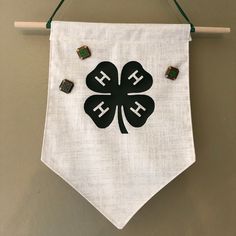 a white banner hanging on a wall with four leaf clovers