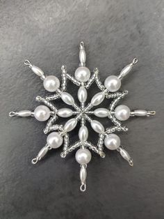 a snowflake made out of pearls and silver wire