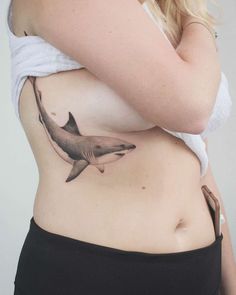 a woman with a shark tattoo on her stomach