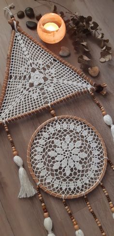 two white doily with tassels on the floor next to a lit candle