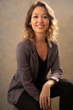 a woman sitting on top of a chair smiling