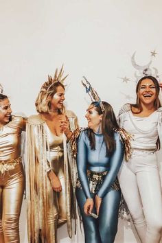 four women dressed in costumes standing next to each other