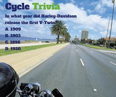 a motorcycle driving down a street next to palm trees and the words cycle trivia in what year did harley davidson release the first v - twin?