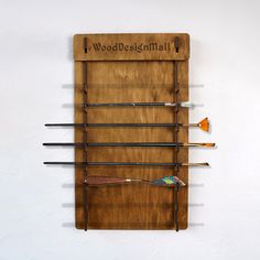 a wall mounted wooden display with different types of paintbrushes on it's sides