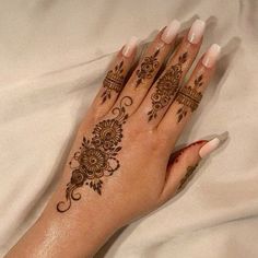 a woman's hand with henna tattoos on it