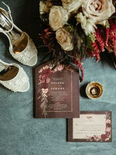 the wedding stationery is laid out with shoes and flowers