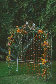 an orange and white wedding arch with flowers on the top is featured in this instagram