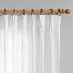 a white curtain with wooden hooks hanging from it's side