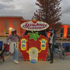 two people standing in front of a car decorated like a strawberry shortcake with the words strawberry shortcake on it