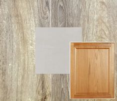 a wood paneled floor with white and gray paint on it, next to a wooden cabinet door