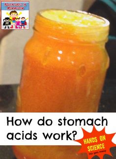 a glass jar filled with orange liquid sitting on top of a counter next to a person