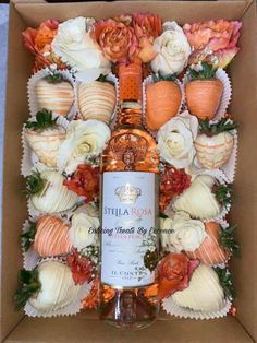 a bottle of stella rose sitting in a box surrounded by flowers and seashells