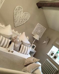 a bed with white and gray pillows in a bedroom next to a radiator