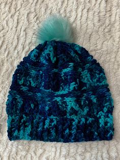 Crochet beanie in shades of blue with light blue faux fur pompom. Blue Warm Beanie One Size, Warm Blue Beanie One Size, Warm Blue Casual Crochet Hat, Casual Warm Blue Crochet Hat, Blue Crochet Hat For Cold Weather, Cozy Blue Beanie One Size, Blue Beanie Hat For Winter, Blue Crochet Winter Hat, Blue One Size Beanie Hat