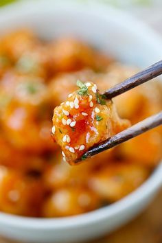 a close up of a fork with food in it and sesame seeds on the side