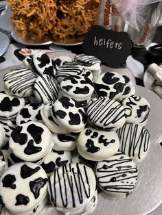 there are many cookies on the plate and one is decorated with black and white icing