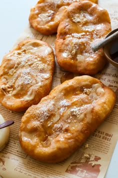 four pastries on a piece of paper with dipping sauce