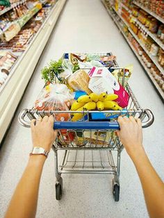 a person pushing a shopping cart in a grocery store