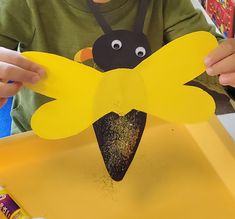 a child is making a paper bee craft