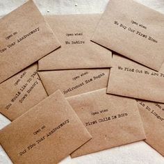 several pieces of brown paper with writing on them sitting on top of a white table cloth