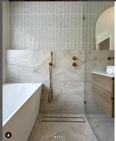 a white bath tub sitting next to a walk in shower