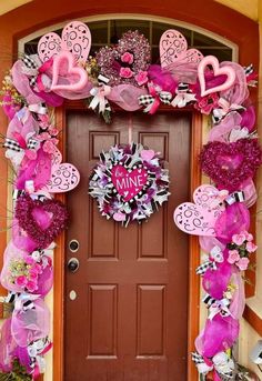 the front door is decorated with pink and purple decorations for valentine's day celebration