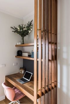 a laptop computer sitting on top of a wooden desk next to a book shelf filled with books