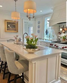 a large kitchen with an island in the middle and two chairs at the counter top