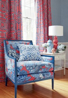 a blue and red chair sitting in front of a window