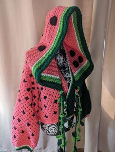 a crocheted watermelon scarf hanging from a curtain