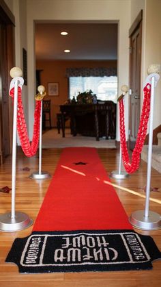 a red carpet and some white poles on the ground with rope barriers in front of it