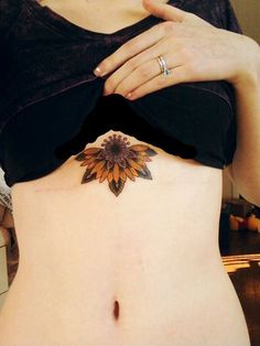 a woman with a sunflower tattoo on her stomach