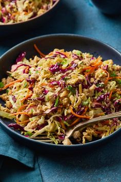 a bowl filled with coleslaw and carrots on top of a blue table