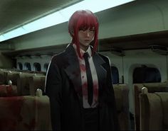 an anime character with red hair wearing a black suit and tie standing in front of some seats