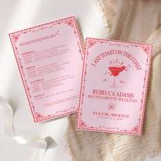 two red and white wedding programs on top of a table with a pink ribbon next to it