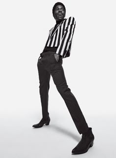 a man in striped shirt and black pants posing