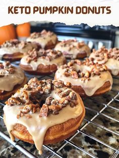 there are many doughnuts with icing and nuts on the cooling rack in the kitchen