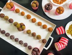 several desserts are arranged on trays next to plates with candy and candies