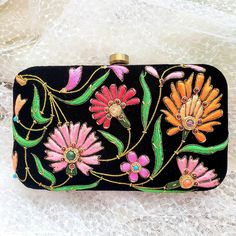 Turn heads wearing this colorful floral embroidered black velvet evening clutch bag. Be bright and bold! This exclusive design is expertly hand embroidered by master zardozi artisans. Each petal and leaf is outlined with glittery metallic gold threads and embellished with genuine semi precious stones, including garnets, turquoise, carnelian and onyx. Shop sustainably - own a handbag of exceptional quality that you will keep forever and pass down to the next generation. View more exclusive embroi Elegant Clutch With Resham Embroidery For Evening, Multicolor Embroidered Handwork Clutch For Party, Festive Evening Clutch With Resham Embroidery, Resham Embroidery Clutch For Evening Festivals, Black Clutch For Festivals Gift, Black Clutch For Festivals As A Gift, Luxury Black Clutch For Festive Occasions, Embroidered Multicolor Clutch For Evening, Black Rectangular Clutch For Festive Occasions