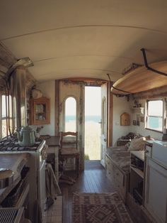 the inside of an old fashioned kitchen and dining area with wood flooring, windows, and cabinets