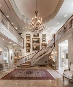 a large foyer with chandelier and paintings on the wall