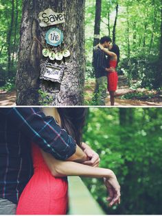 two people standing next to each other in the woods with trees and signs on them