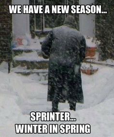 a man walking down a snow covered street in the middle of winter with words written on it