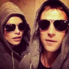 two people wearing hoodies and sunglasses taking a selfie