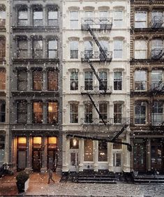 an apartment building in the snow with fire escapes on each floor and stairs leading up to it