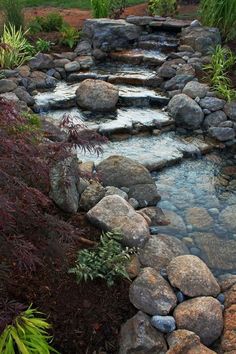 an image of a river in the middle of some rocks and plants with water running through it