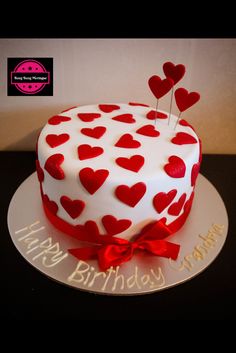 a white cake with red hearts on it