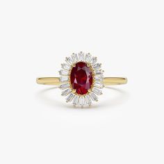 a yellow gold ring with an oval shaped ruby and baguettes set in the center