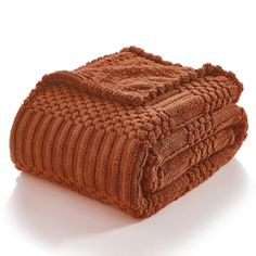 two brown towels stacked on top of each other in front of a white background,