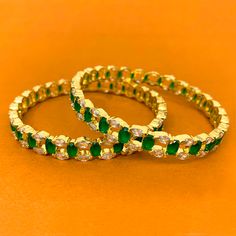 Unique and Stunning, White American Diamond and Green Semi-Precious Emerald stone bangles. These bangles are in gold-tone and will match a variety of outfits. You can wear them with formal traditional outfits, western outfits, or even informal casual gatherings. Best for gifting or for personal use, wear it to any occasion and be the spotlight. Eye-catching and unique jewelry that will set you apart. Gift this piece to a loved one, and see their face light up with joy. Stone Bangles, Bangles Design, Stone Bangle, Face Light, Bangle Designs, Of Outfits, Emerald Stone, American Diamond, Western Outfits